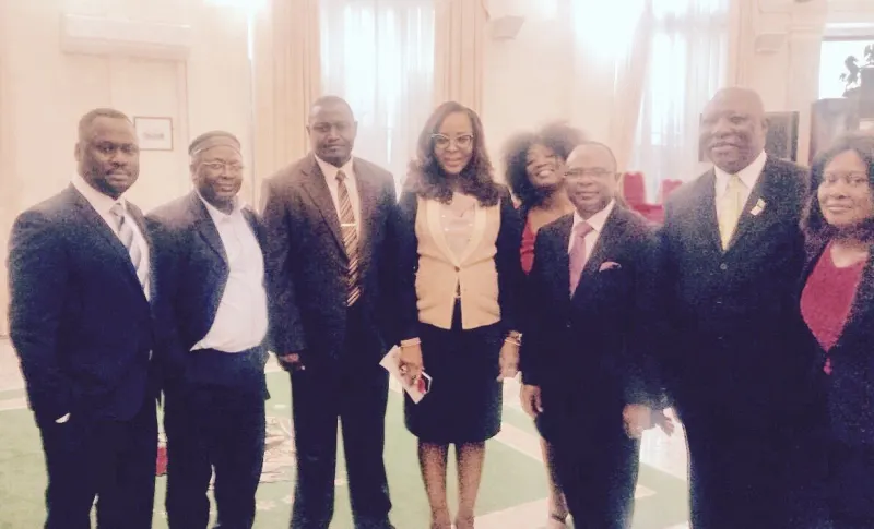 Eight EFN members in business dress stand together in a reception room.