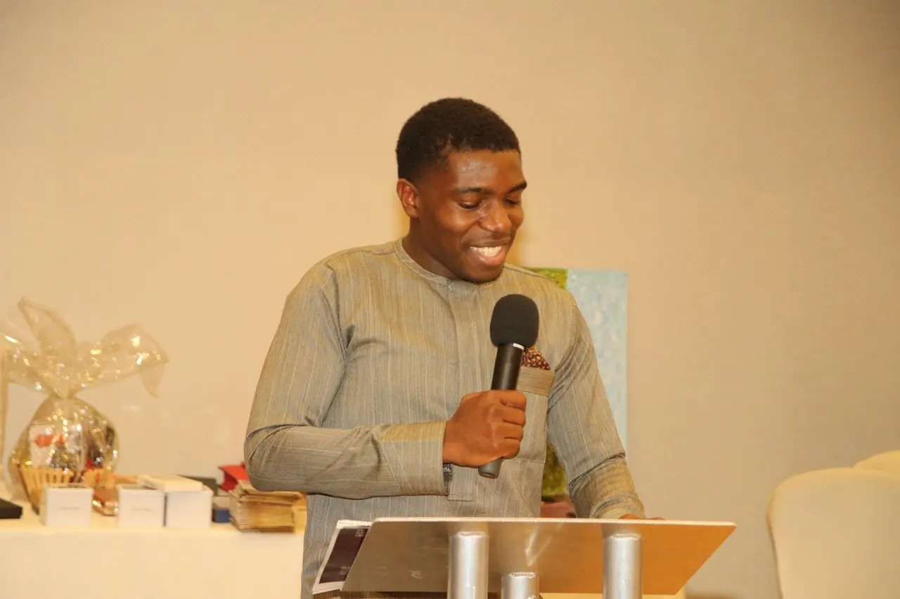 A young engineer speaks into a microphone at an evening with the engineers.