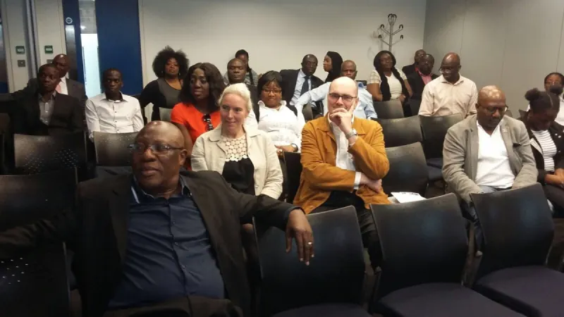 Participants seated in rows, listening to a presentation.