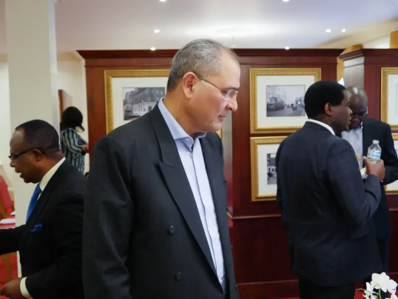 Delegates talk in a wood-panelled room hung with framed photographs.