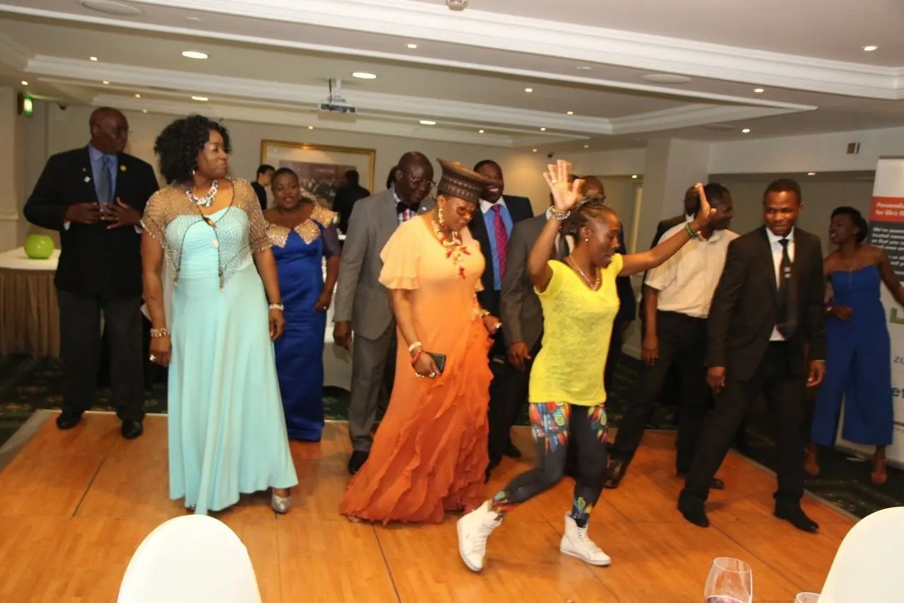 Guests in colourful gowns and Nigerian traditional dress dancing on the dance floor.